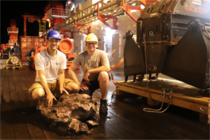 Christoph Beier und Bernd Schleifer mit einem Basalt vor dem TV-Greifer (S. Krumm, FAU)